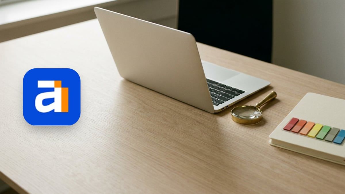 Ahrefs icon beside an open laptop seen side-on, a brass magnifying glass and coloured sticky tabs on a notebook
